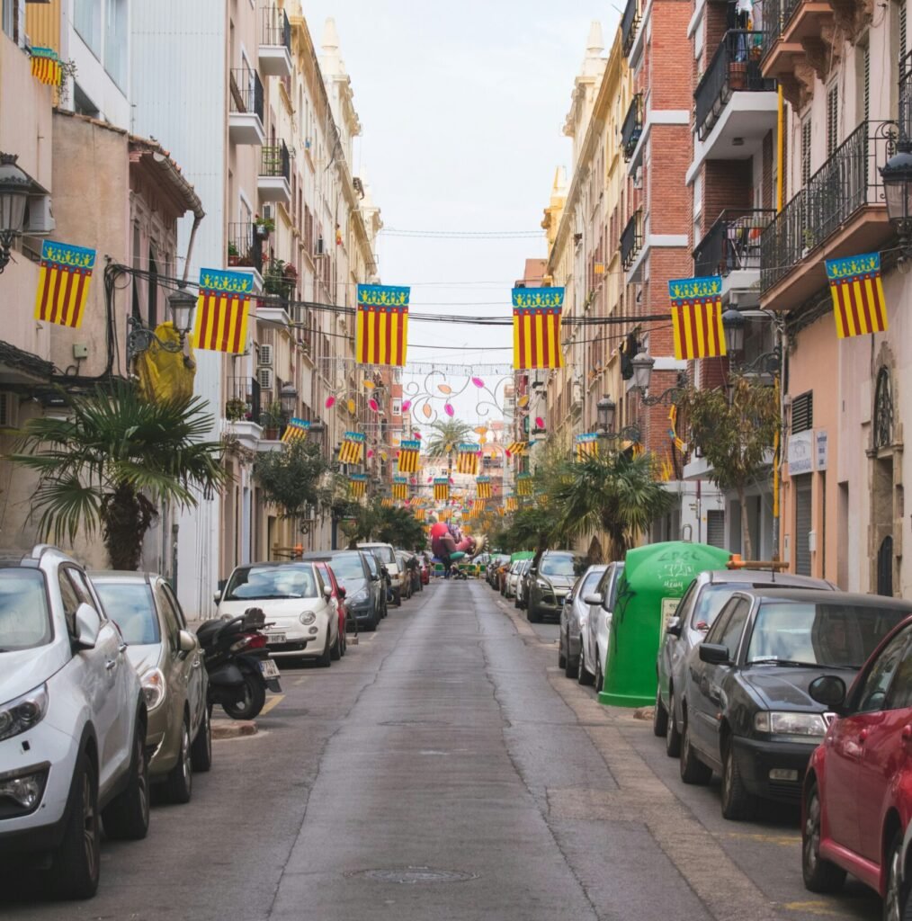 a street lined with parked cars next to tall buildings