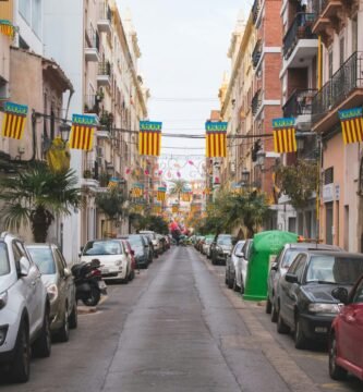 a street lined with parked cars next to tall buildings