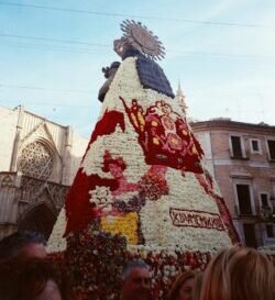 a large christmas tree made of flowers in front of a building